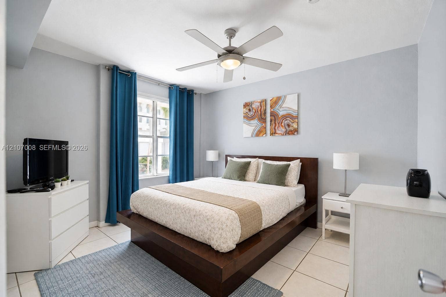 3030 Collins Avenue, #2H, Miami Beach, FL 33140 Light-filled room featuring large format tile flooring, a multi-blade ceiling fan with integrated lighting, and a multi-pane window