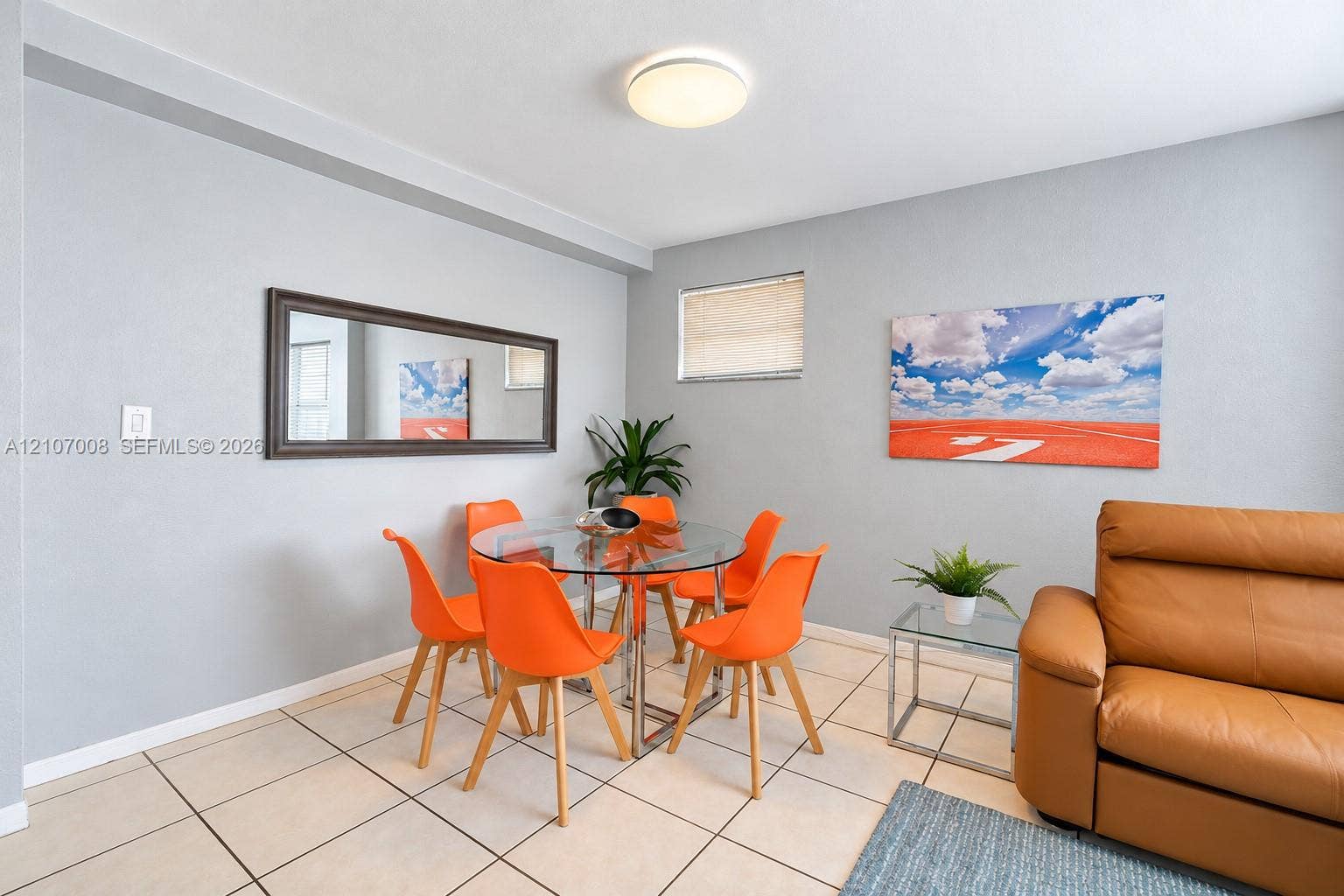 3030 Collins Avenue, #2H, Miami Beach, FL 33140 Neutral-toned interior featuring large-format ceramic tile flooring, a mounted rectangular mirror with a dark frame, and a flush-mount dome ceiling light