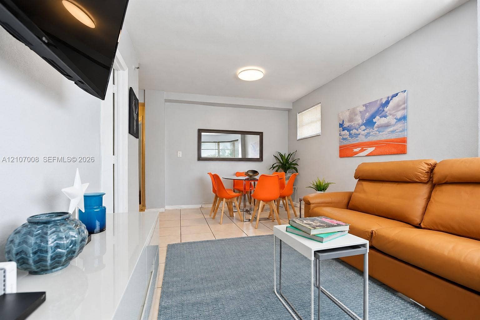 3030 Collins Avenue, #2H, Miami Beach, FL 33140 Neutral-toned interior space featuring tile flooring, a recessed mirror, and flush-mount ceiling lighting