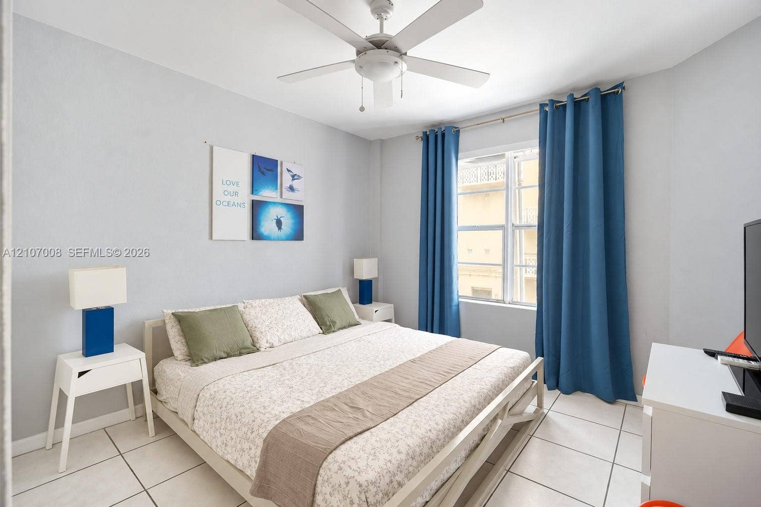 3030 Collins Avenue, #2H, Miami Beach, FL 33140 Neutral-toned room featuring a central ceiling fan with integrated lighting, tile flooring, and a multi-pane window