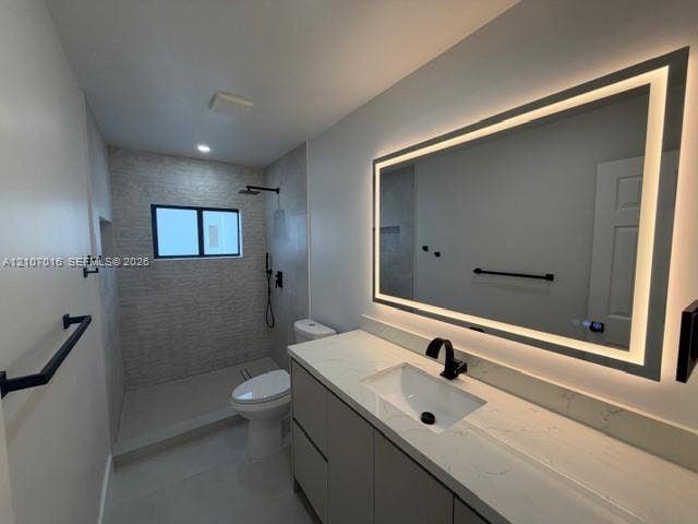 Modern bathroom featuring a modern vanity with a light-toned countertop, rectangular undermount sink, matte black faucet, and an integrated LED-lit vanity mirror