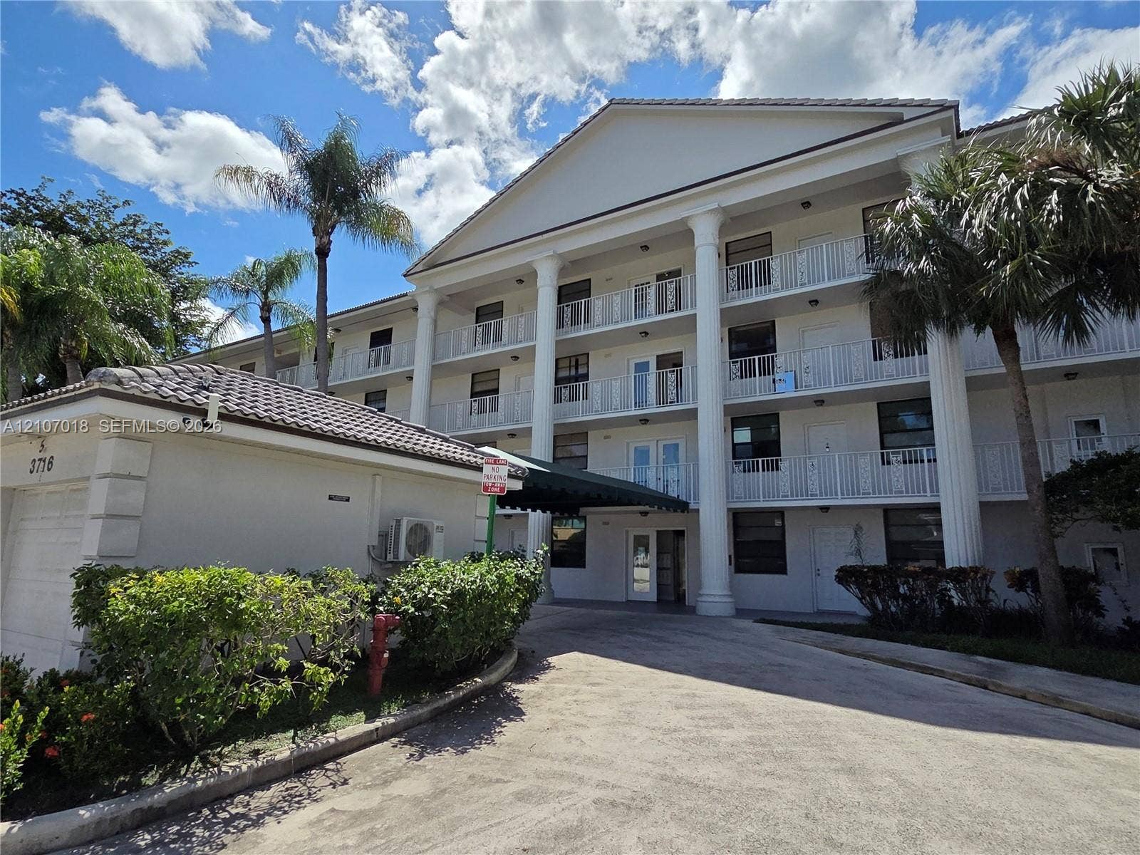3716 Whitehall Drive, #304, West Palm Beach, West Palm Beach, FL 33401 Three-story exterior featuring a prominent pediment, classic multi-story columns, and tiered white railing balconies