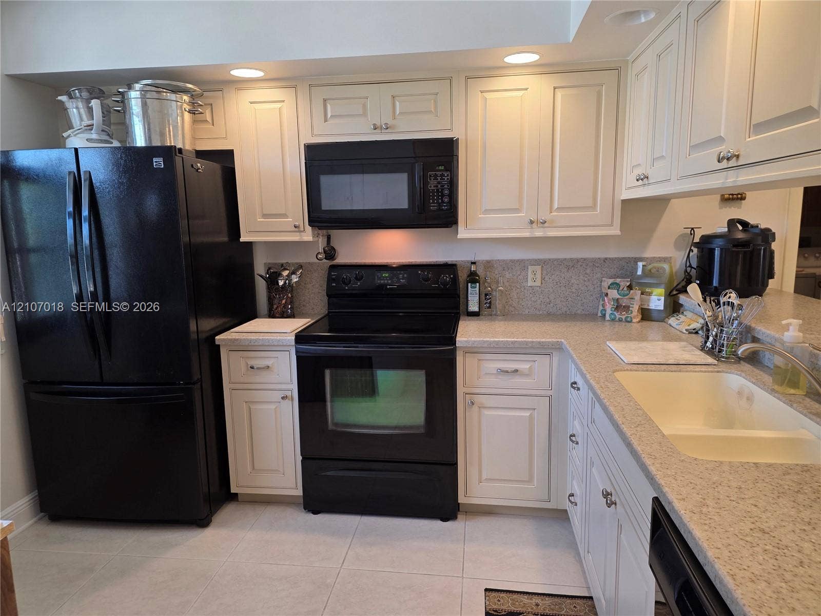3716 Whitehall Drive, #304, West Palm Beach, West Palm Beach, FL 33401 Kitchen featuring off-white cabinetry, black appliances, solid surface countertops, a dual-basin sink, and recessed lighting