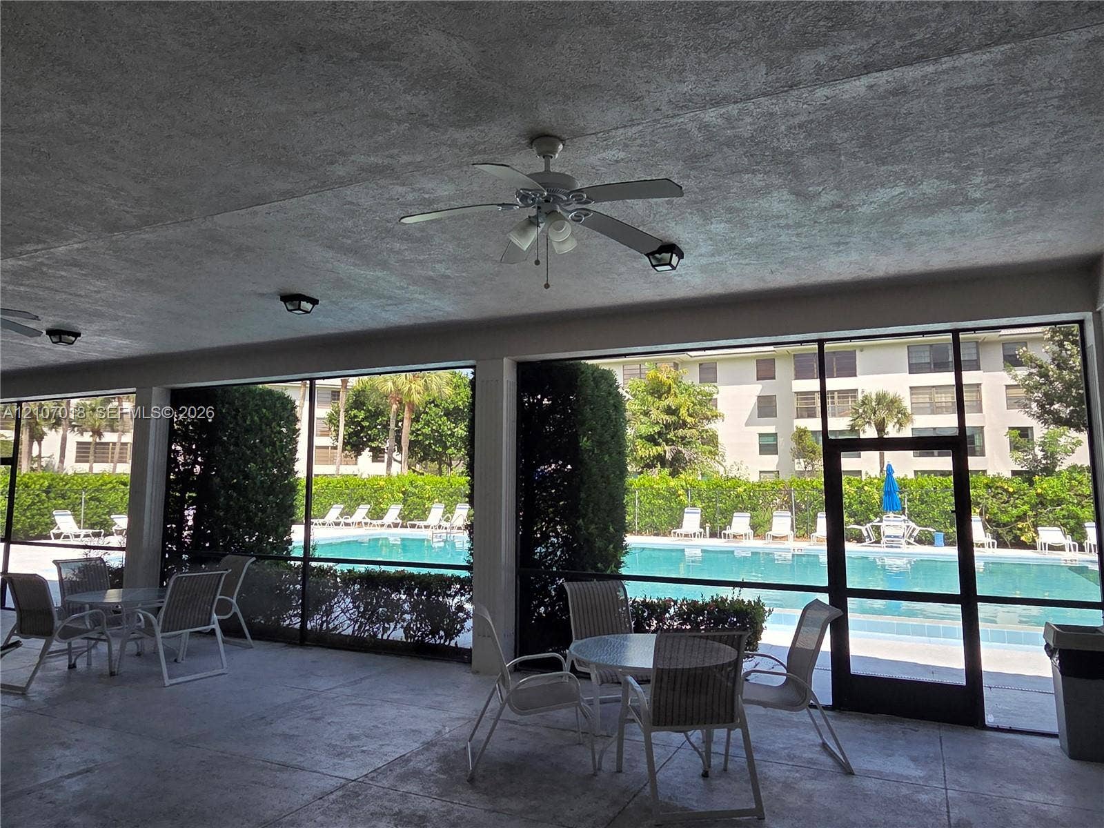 3716 Whitehall Drive, #304, West Palm Beach, West Palm Beach, FL 33401 Covered outdoor patio featuring a concrete floor, built-in ceiling fans, recessed lighting, and a screened enclosure
