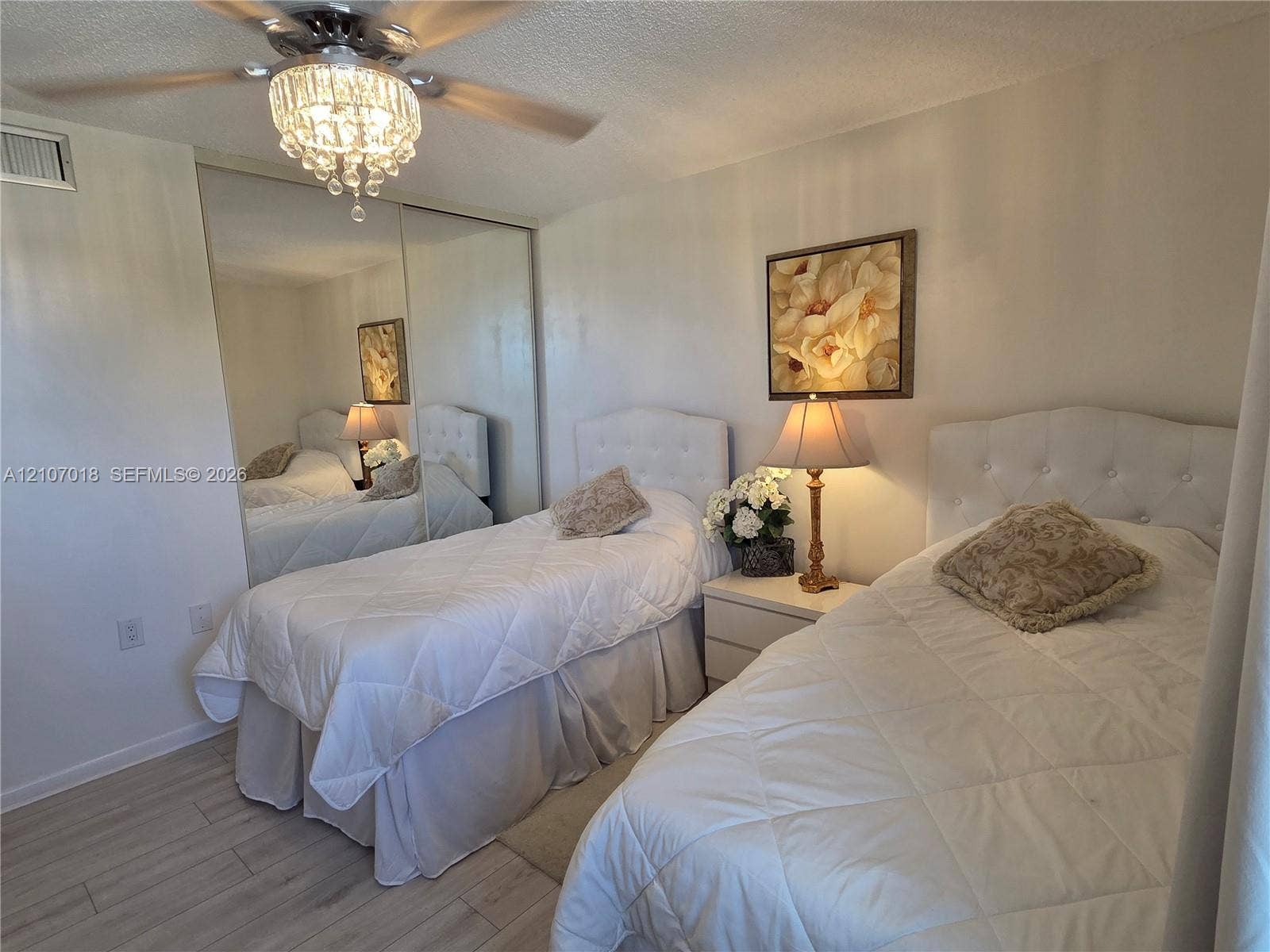 3716 Whitehall Drive, #304, West Palm Beach, West Palm Beach, FL 33401 Wood-finish flooring, full-wall mirrored sliding closet doors, and a crystal-accented ceiling fan with light fixture