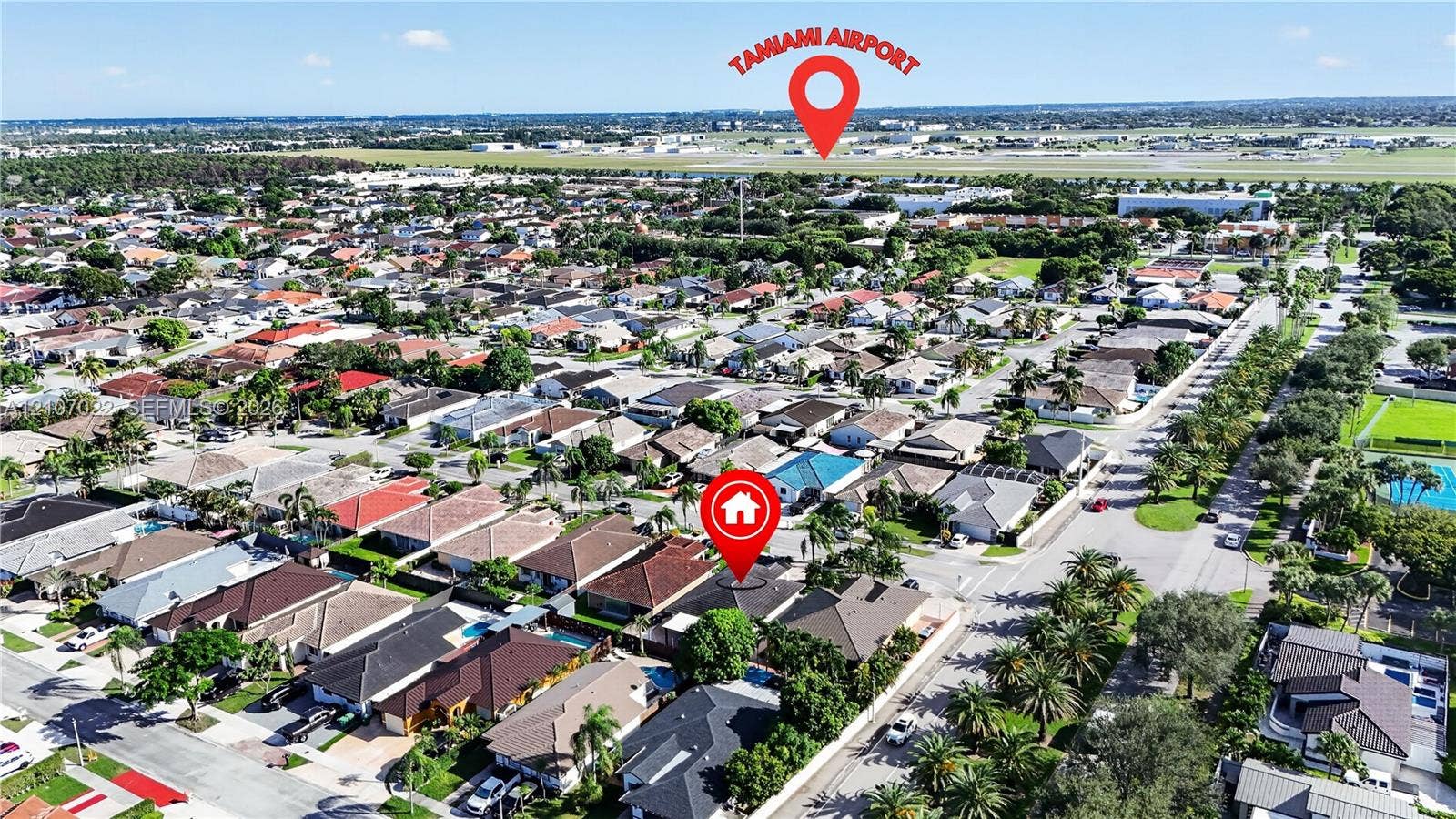 Aerial perspective of a residential neighborhood featuring paved streets, mature canopy trees, and proximity to regional aviation infrastructure