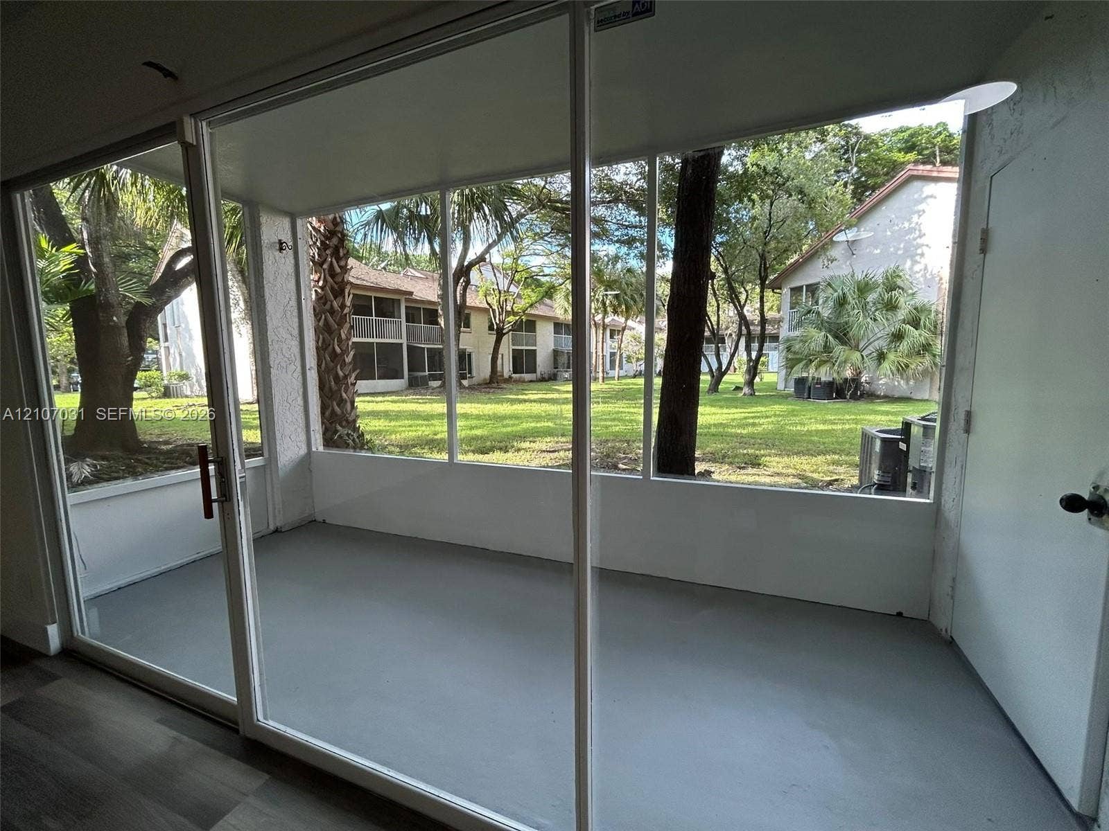 Enclosed porch featuring floor-to-ceiling screened panels, solid flooring, and exterior door access