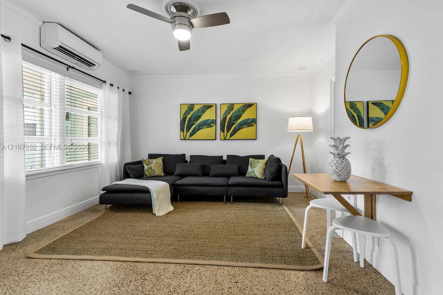 443 NE 17th Way, Fort Lauderdale, FL 33301 Interior space featuring speckled composite flooring, a wall-mounted ductless air conditioning unit, and a ceiling fan with integrated lighting