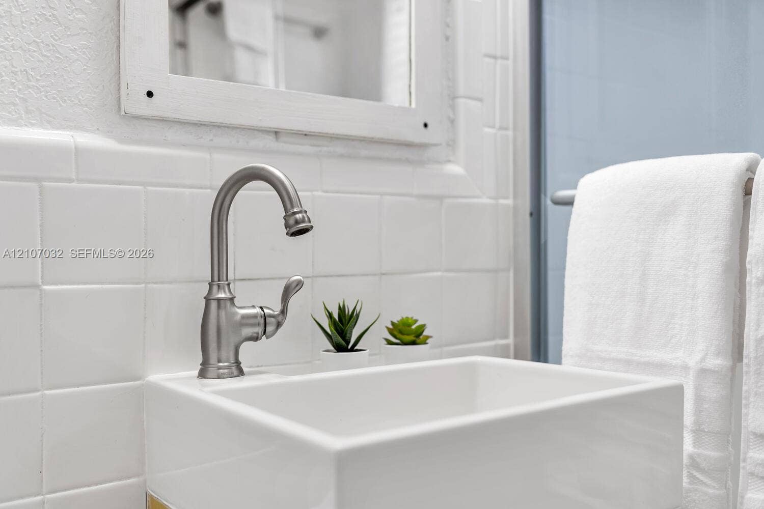 443 NE 17th Way, Fort Lauderdale, FL 33301 Wall-mounted square sink featuring a brushed nickel high-arc faucet and matte white tiled backsplash