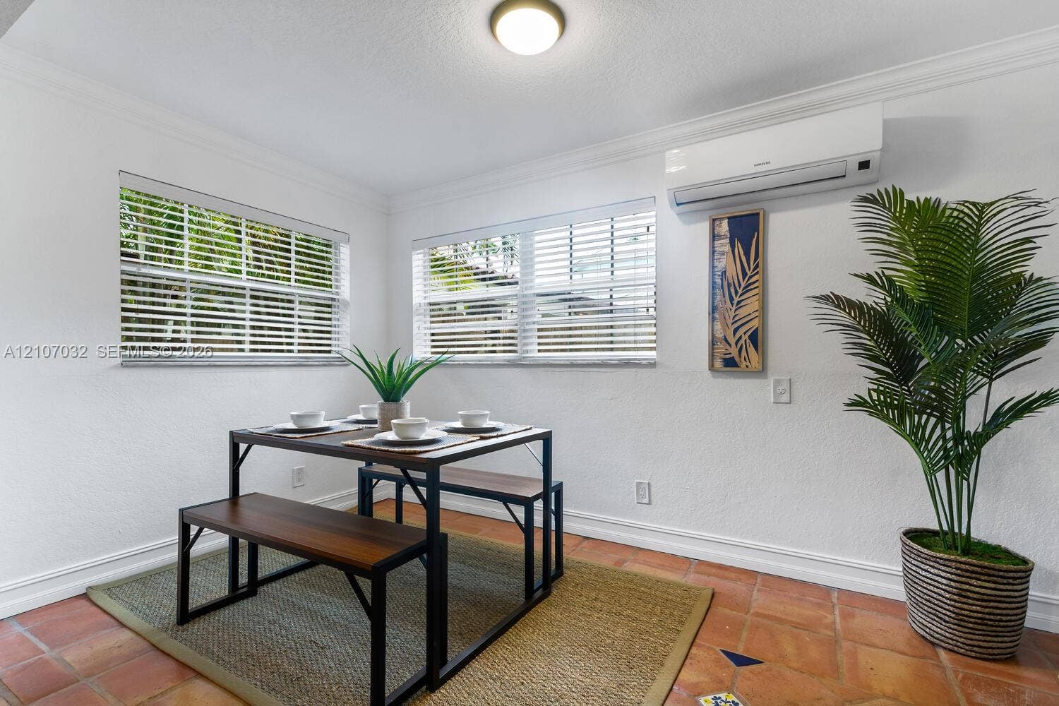 443 NE 17th Way, Fort Lauderdale, FL 33301 Terra-cotta tile flooring, dual windows with horizontal blinds, wall-mounted ductless climate control system, crown molding, and a flush-mount ceiling light fixture
