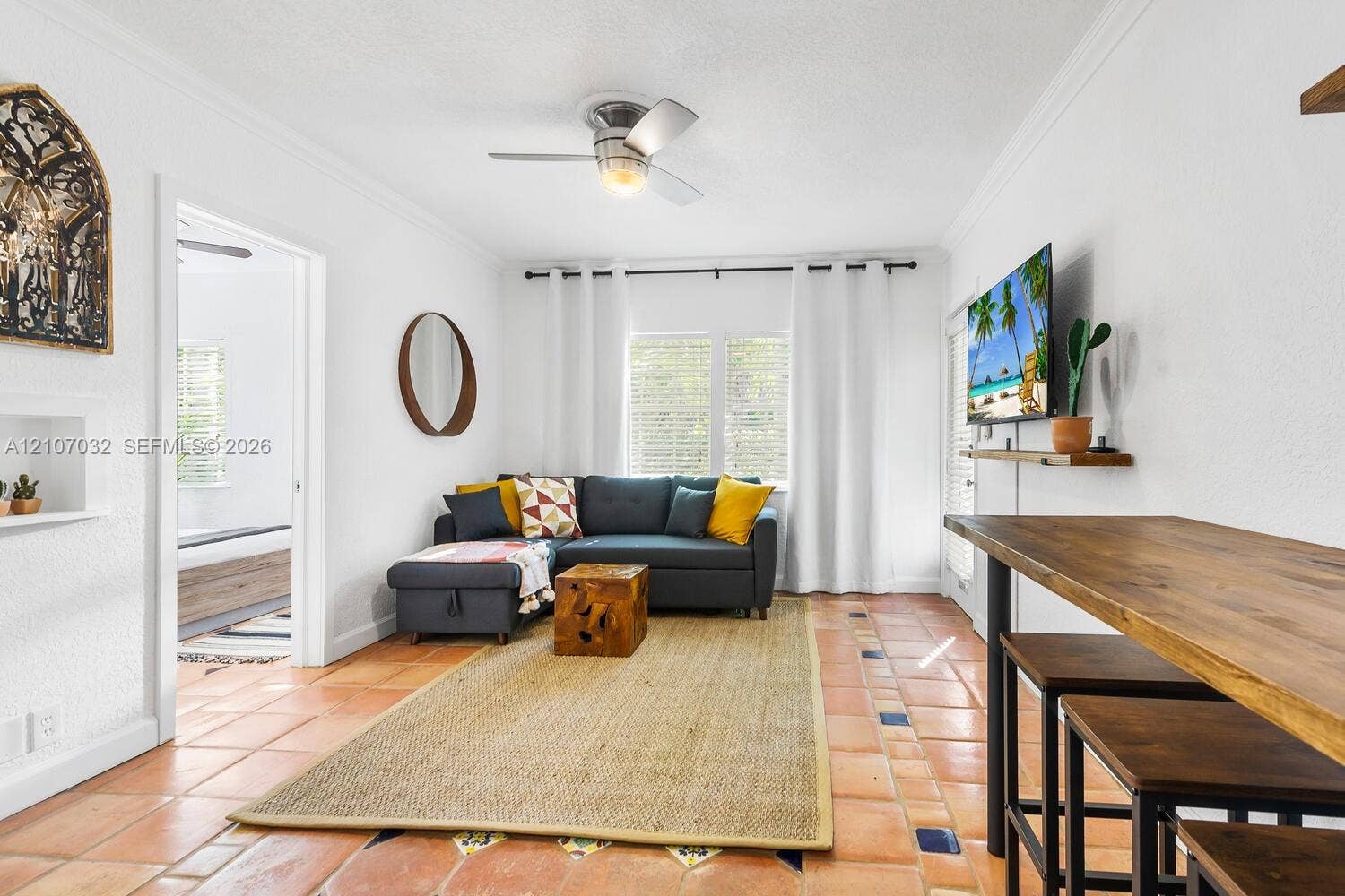 443 NE 17th Way, Fort Lauderdale, FL 33301 Terra-cotta tile flooring with decorative accent inlays, crown molding, built-in wall niche, and ceiling fan with integrated lighting