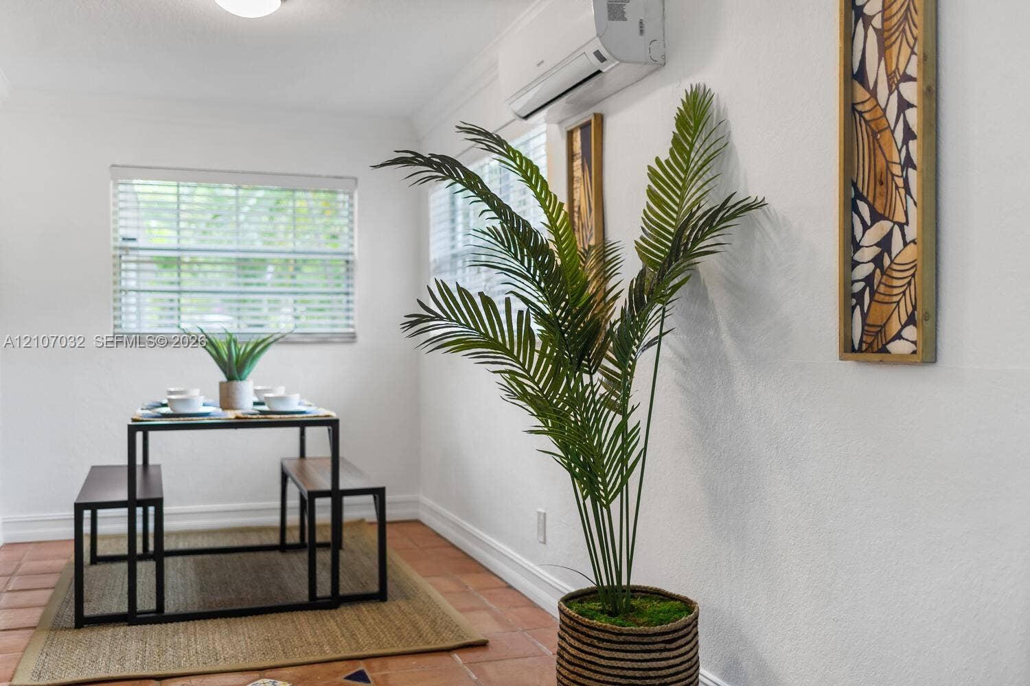 443 NE 17th Way, Fort Lauderdale, FL 33301 Interior space featuring ceramic tile flooring, dual-pane windows with horizontal blinds, and a wall-mounted ductless heating and cooling unit