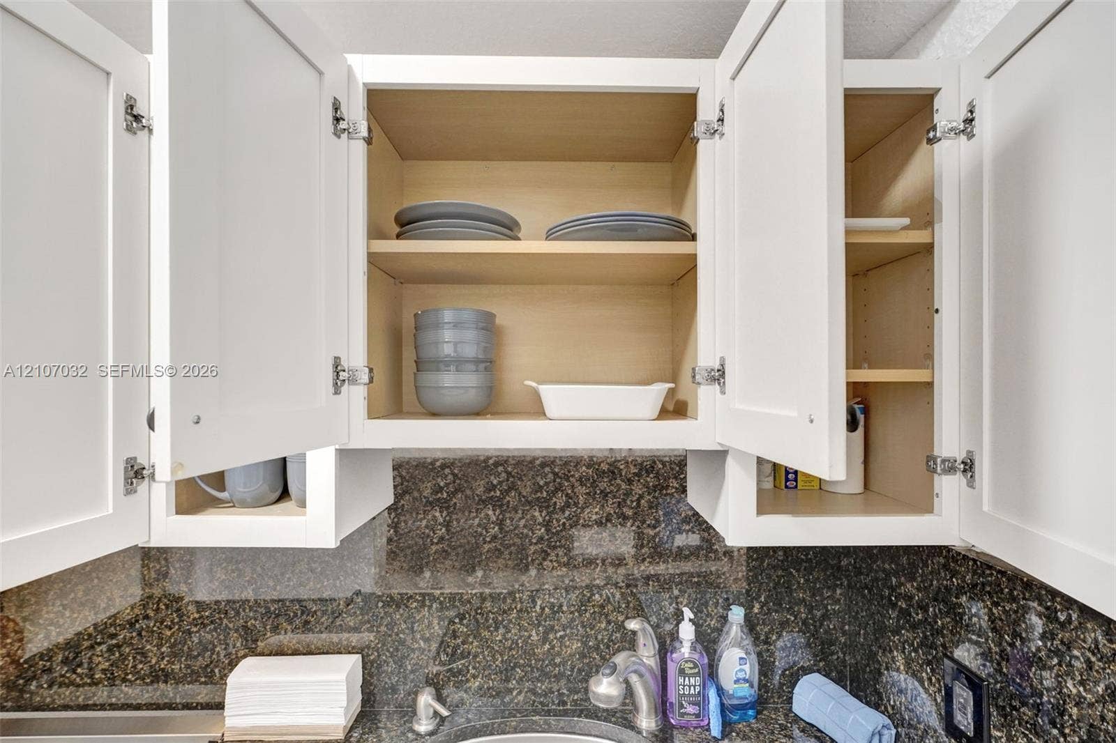 443 NE 17th Way, Fort Lauderdale, FL 33301 Shaker-style white cabinetry with adjustable shelving and a dark stone-finish backsplash