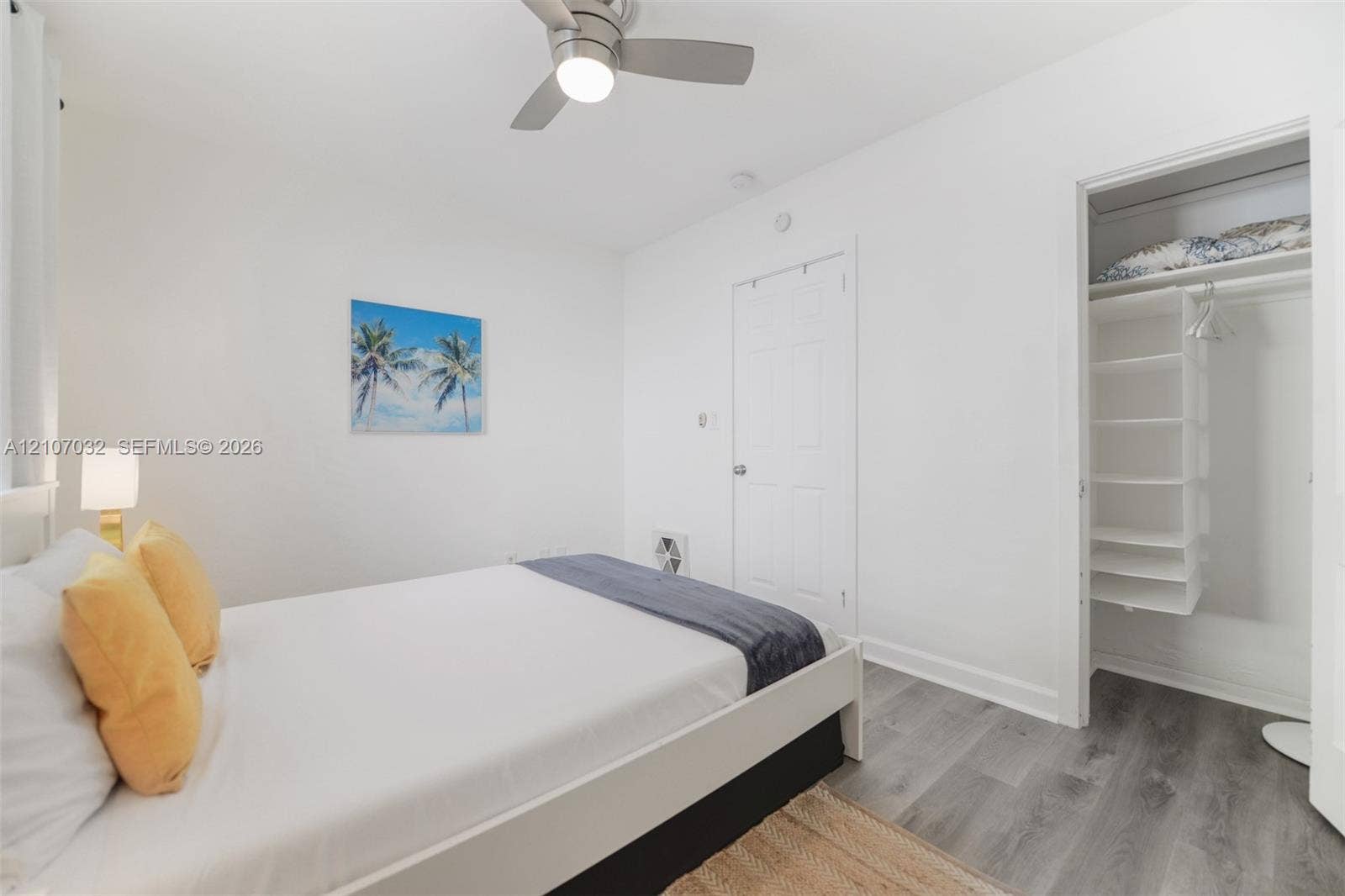 443 NE 17th Way, Fort Lauderdale, FL 33301 Interior space featuring wood-finish flooring, a ceiling fan with integrated lighting, and a closet with built-in shelving