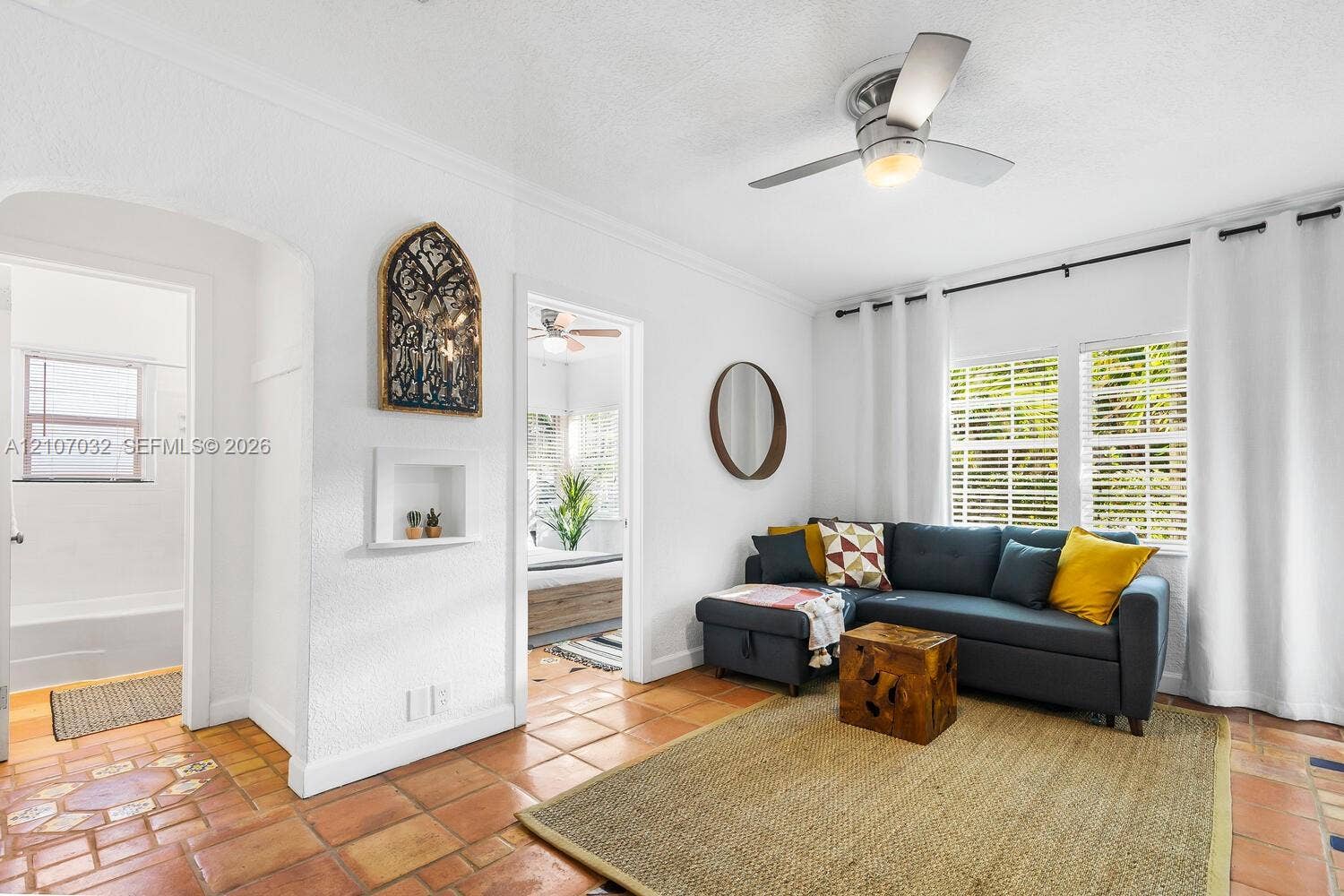 443 NE 17th Way, Fort Lauderdale, FL 33301 Terra cotta tile flooring, arched doorway, recessed wall niche, and brushed nickel ceiling fan