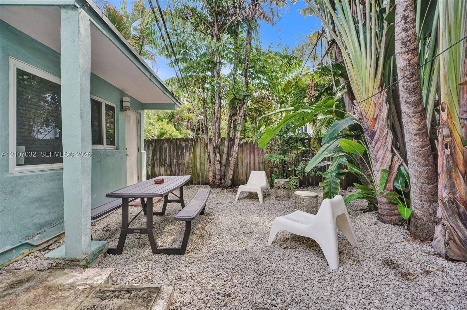 443 NE 17th Way, Fort Lauderdale, FL 33301 Exterior patio space featuring a gravel ground surface, privacy fencing, and established tropical vegetation