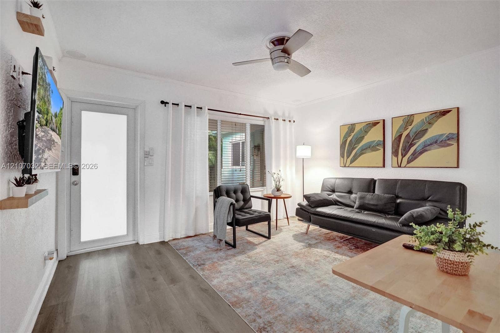 443 NE 17th Way, Fort Lauderdale, FL 33301 Living area featuring wood-finish flooring, a ceiling fan, and a glass-panel exterior door