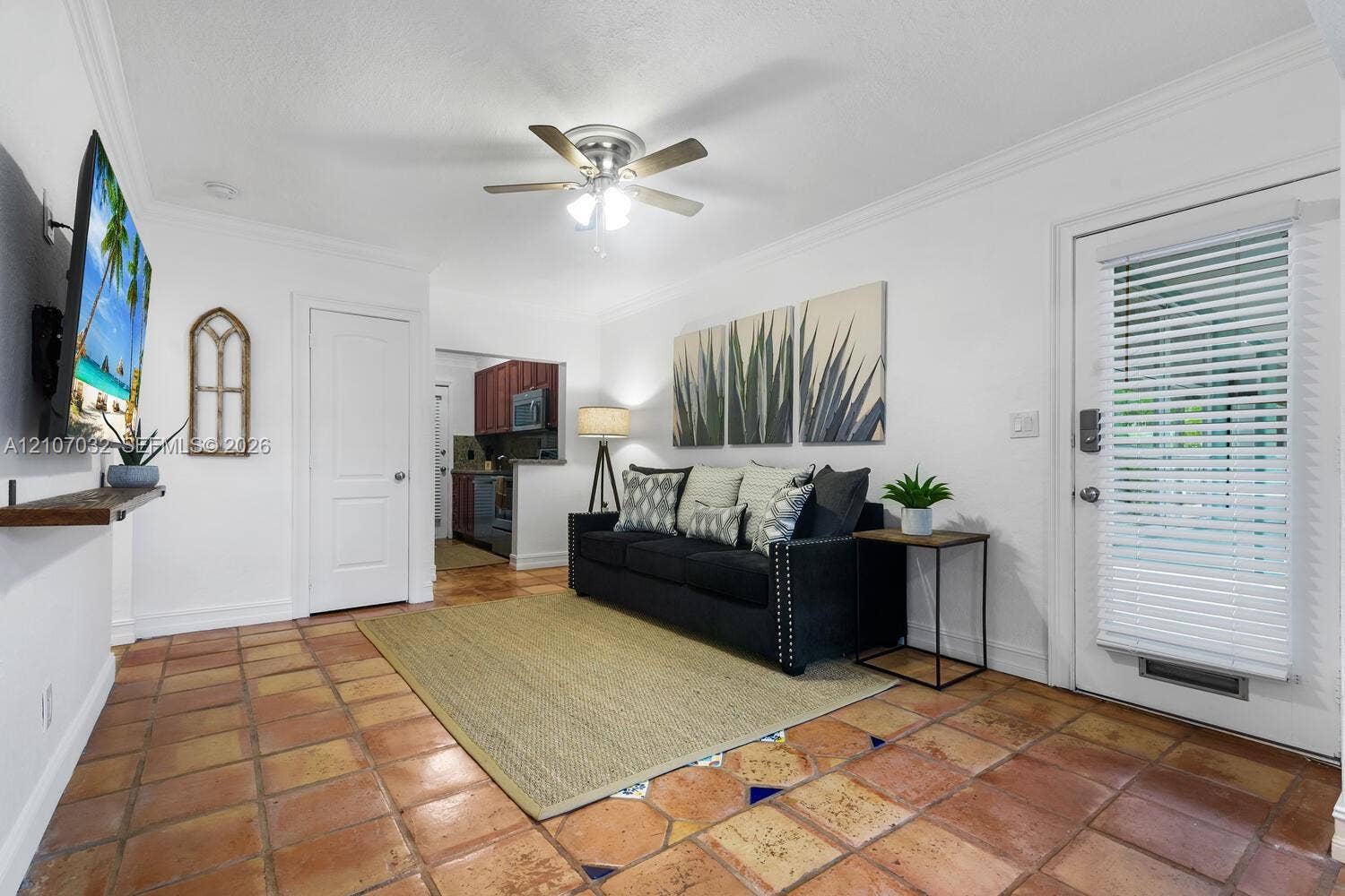 443 NE 17th Way, Fort Lauderdale, FL 33301 Terra-cotta tile flooring, crown molding, ceiling fan with integrated lighting, and a solid-panel interior door