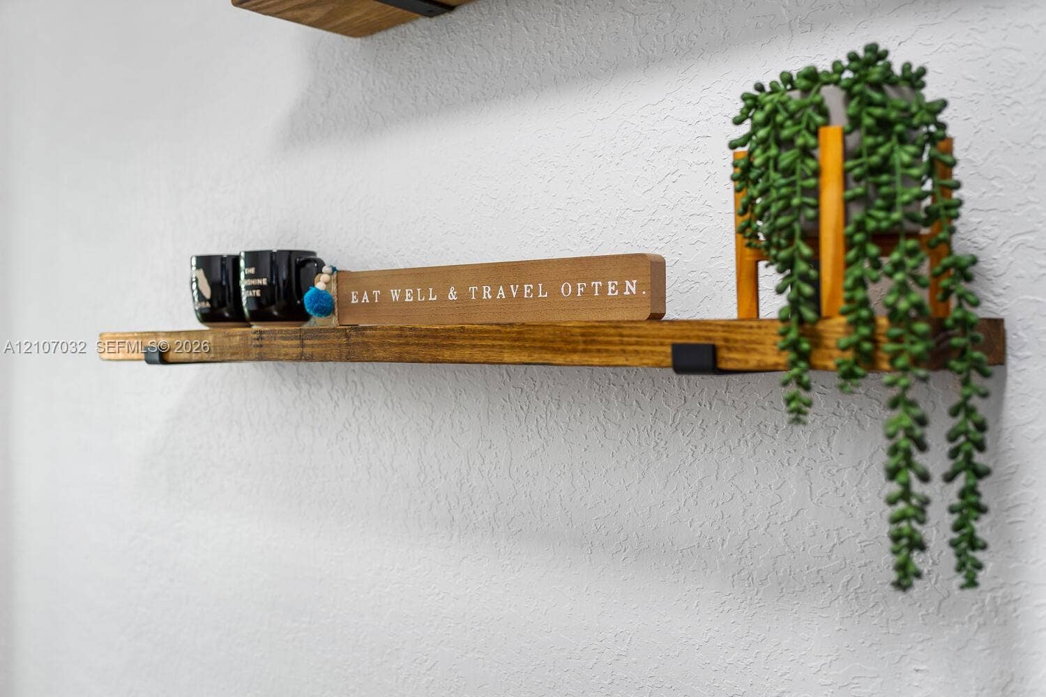 Wall-mounted natural wood shelving featuring matte black metal support brackets
