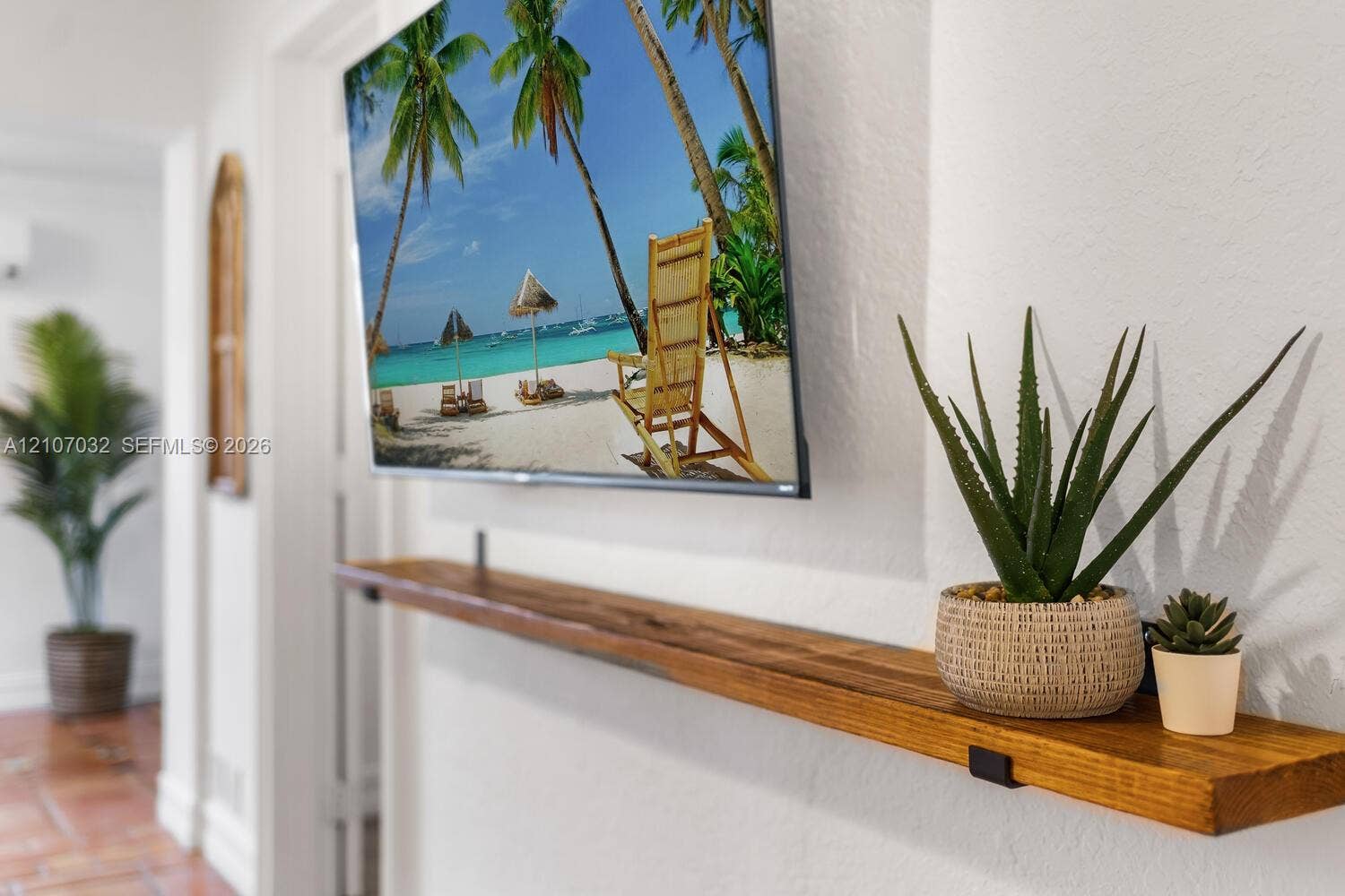 443 NE 17th Way, Fort Lauderdale, FL 33301 Wall-mounted wood floating shelf with matte black metal brackets and textured white wall finish