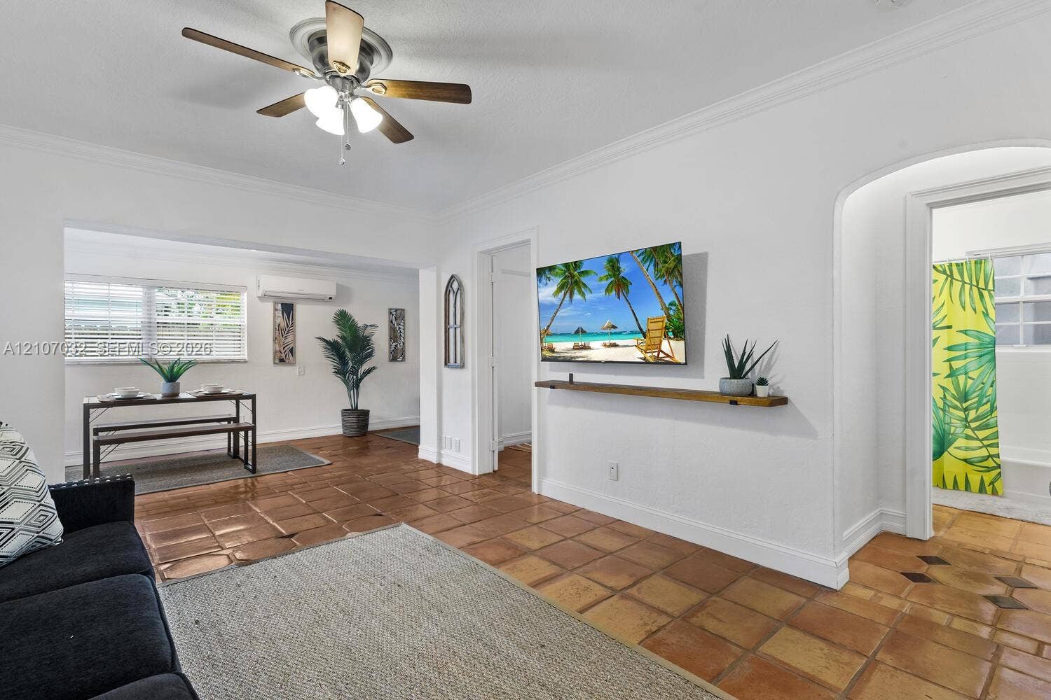 443 NE 17th Way, Fort Lauderdale, FL 33301 Ceramic tile flooring, crown molding, arched entryways, wall-mounted display shelf, and ceiling fan with integrated lighting