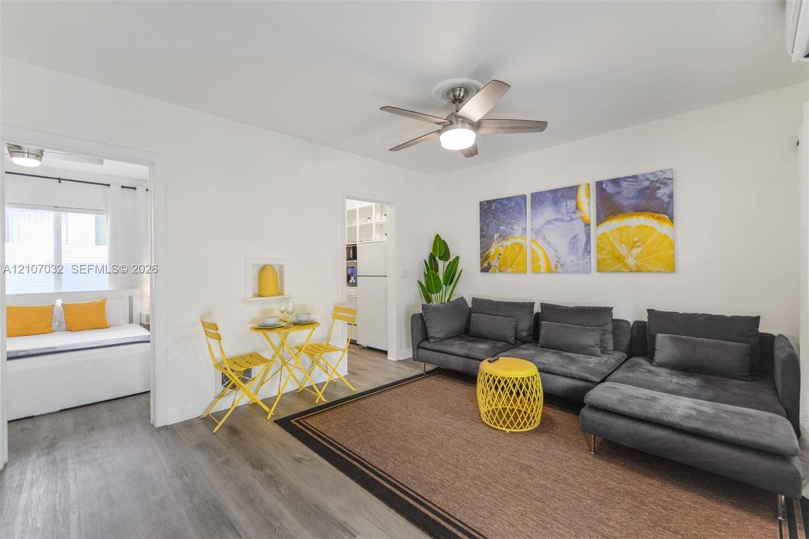 443 NE 17th Way, Fort Lauderdale, FL 33301 Living area featuring wood-finish flooring, a ceiling fan with integrated lighting, and a recessed wall niche