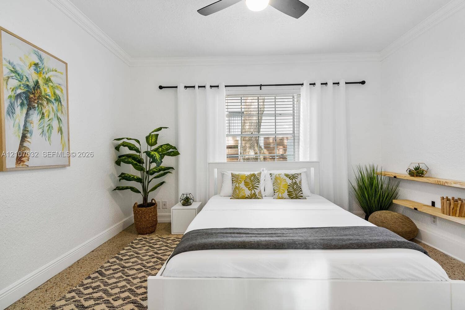 443 NE 17th Way, Fort Lauderdale, FL 33301 Neutral-toned interior featuring textured flooring, crown molding, double-hung window with wood-blind treatments, and custom wood shelving