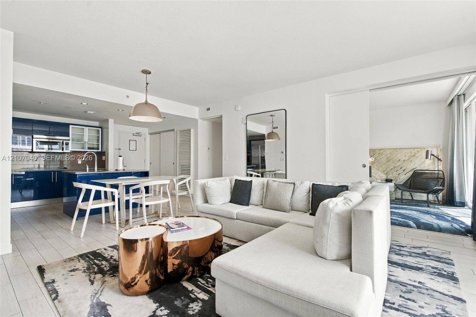 3101 Bayshore Drive, #707, Fort Lauderdale, FL 33304 Open-concept kitchen featuring high-gloss navy cabinetry, stainless steel appliances, and a central island with a built-in sink