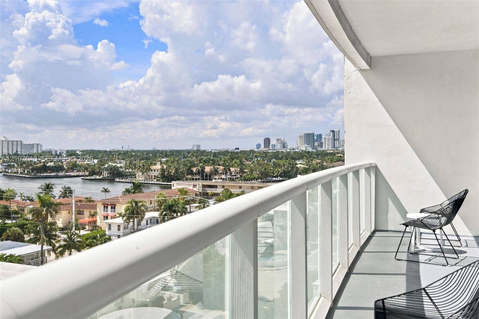 3101 Bayshore Drive, #707, Fort Lauderdale, FL 33304 Covered balcony with a glass panel railing, showcasing panoramic water and cityscape scenery