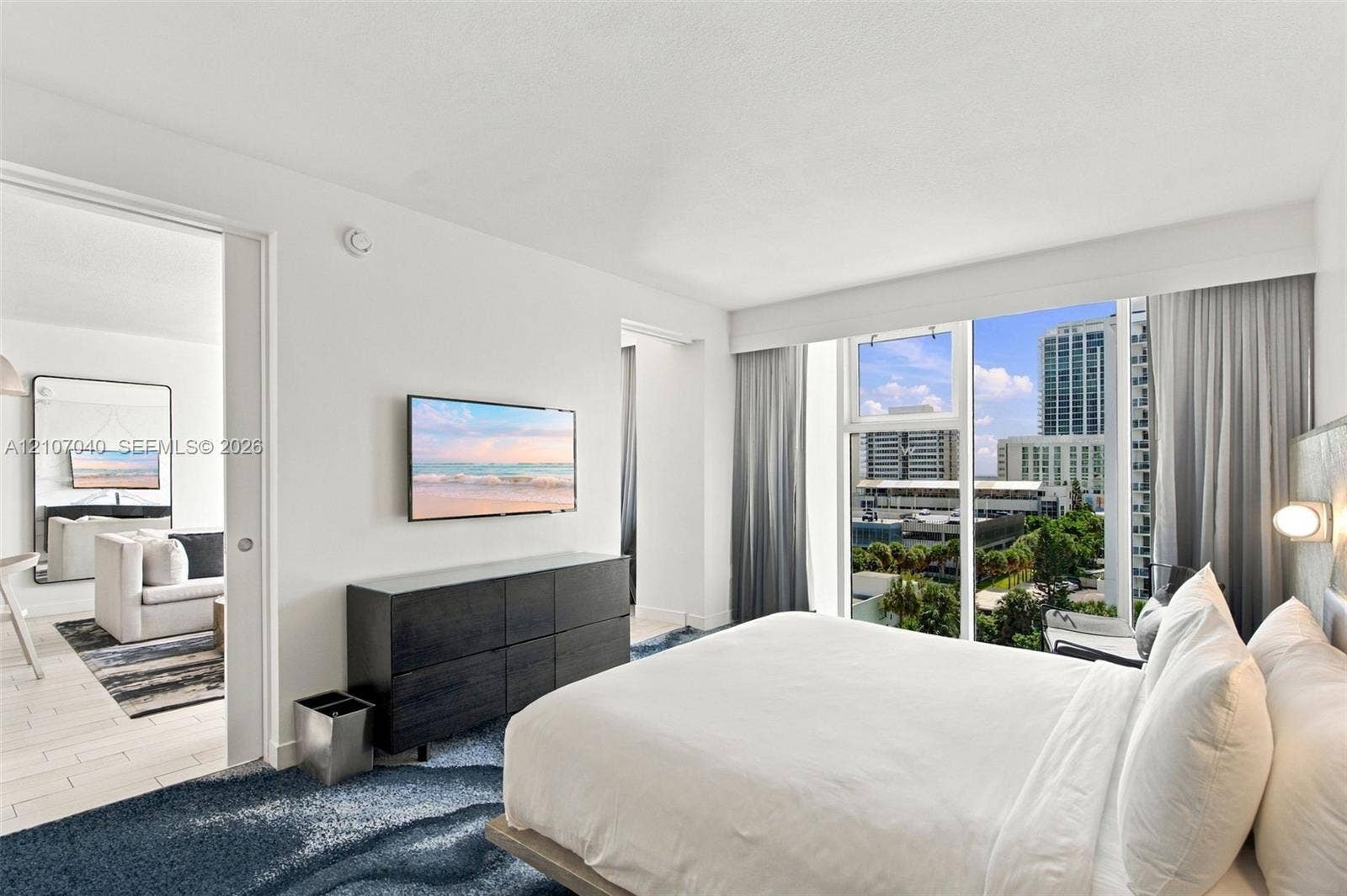 3101 Bayshore Drive, #707, Fort Lauderdale, FL 33304 Floor-to-ceiling windows, sliding pocket door, wood-finish flooring, and wall-mounted light fixtures