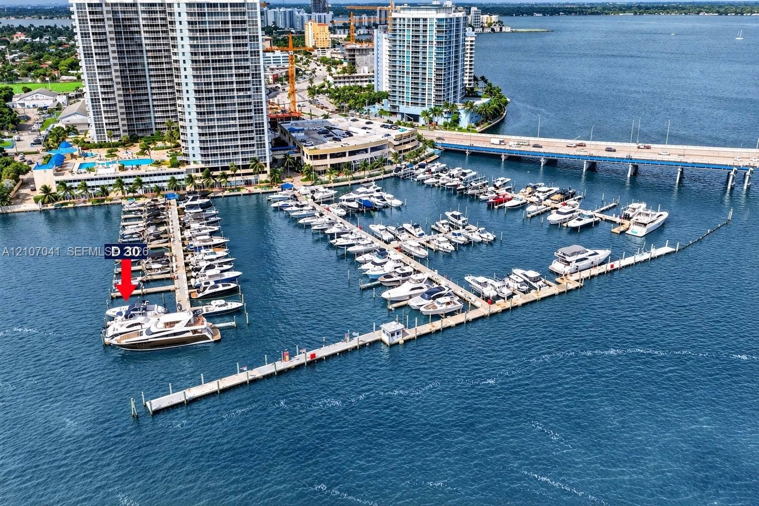 Deep-water marina slip D30 featuring direct harbor access, concrete piling construction, and utility hookups, situated within a protected coastal waterway