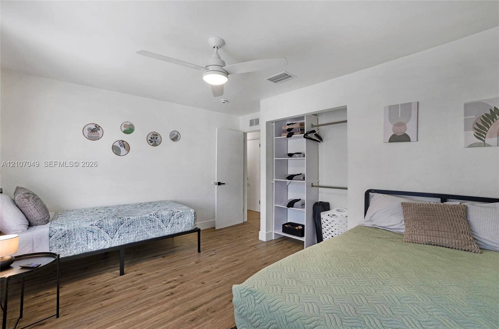 1009 NE 18th Street, Fort Lauderdale, FL 33305 Wood-finish flooring, ceiling fan with integrated lighting, and built-in closet shelving