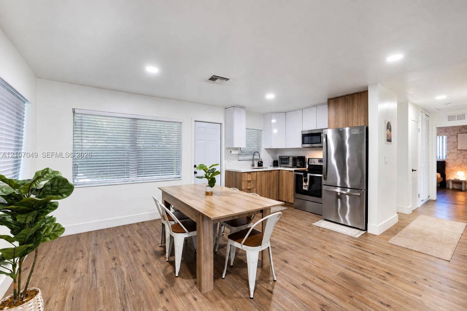 1009 NE 18th Street, Fort Lauderdale, FL 33305 Kitchen featuring two-tone cabinetry with wood-finish lower cabinets, stainless steel appliances, recessed lighting, and wood-finish flooring