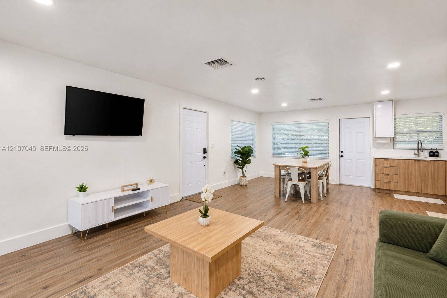 1009 NE 18th Street, Fort Lauderdale, FL 33305 Open-concept interior featuring wood-finish flooring, recessed lighting, and a kitchenette with wood-finish cabinetry