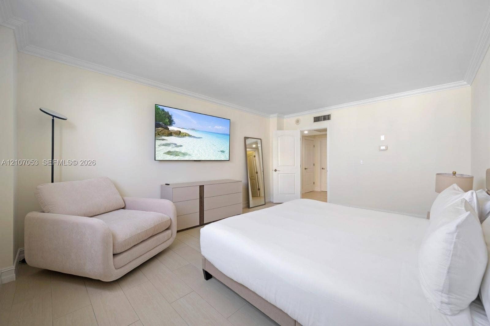 19370 Collins Avenue, #1403, Sunny Isles Beach, FL 33160 Neutral-toned wood-finish flooring, crown molding, and a solid-core interior door