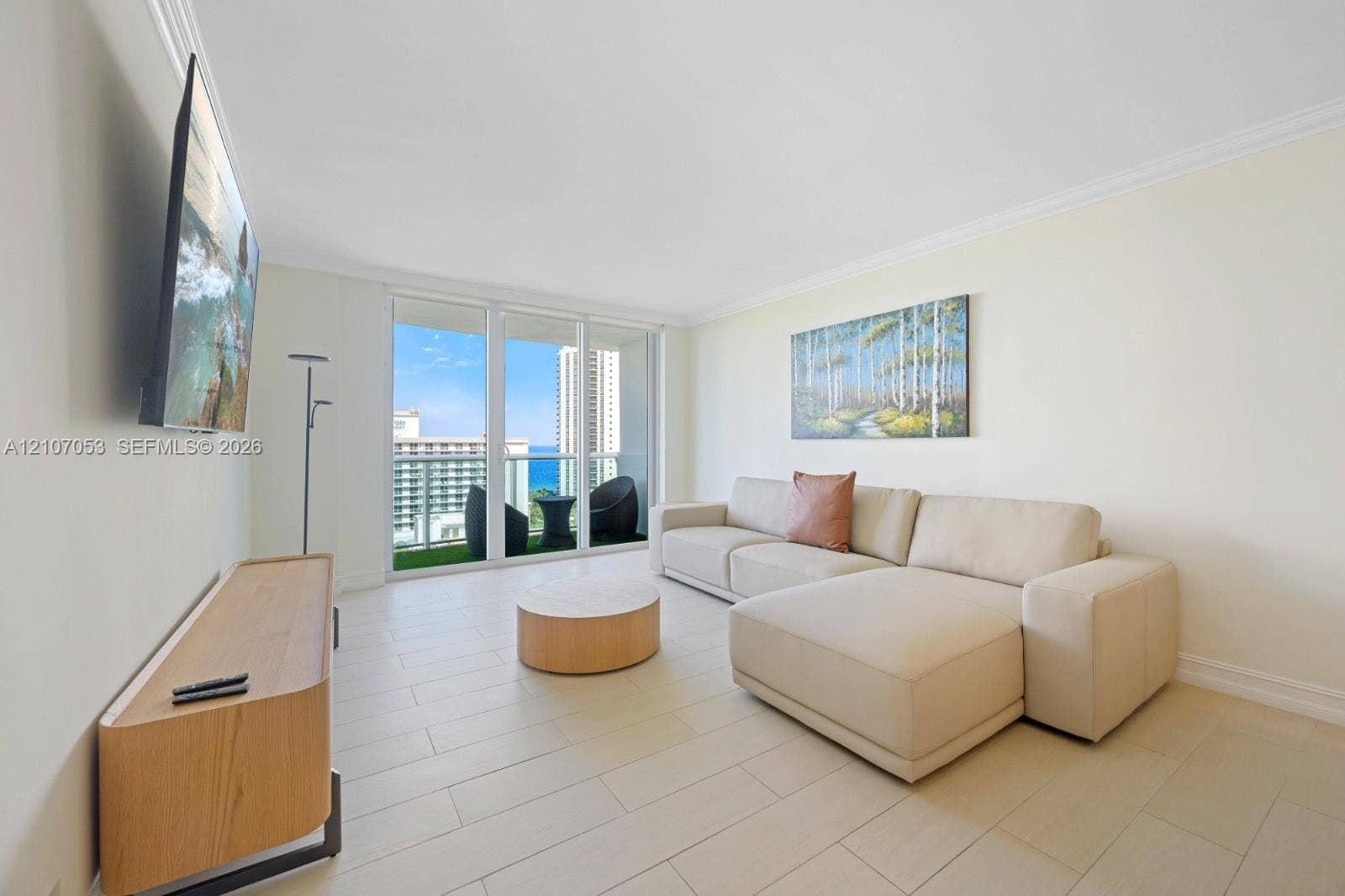 19370 Collins Avenue, #1403, Sunny Isles Beach, FL 33160 Light-toned tile flooring, crown molding, and floor-to-ceiling glass sliding doors opening to a private balcony