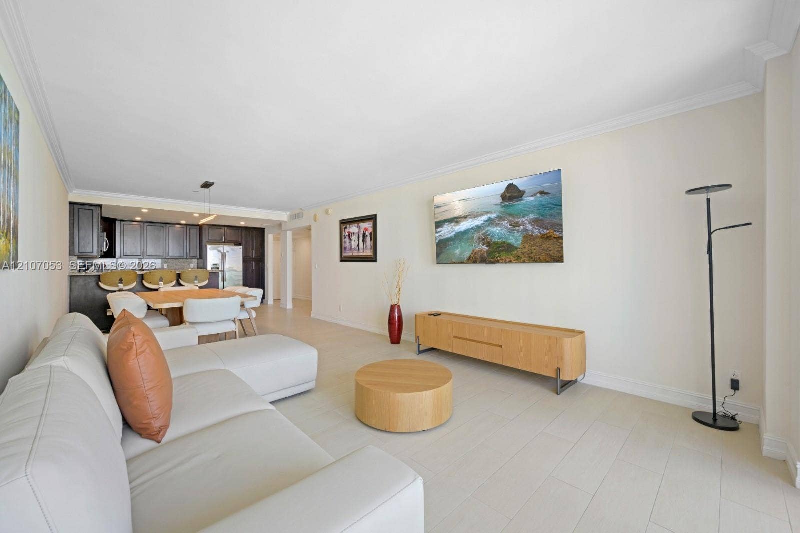 19370 Collins Avenue, #1403, Sunny Isles Beach, FL 33160 Open-concept living space featuring light-toned flooring, crown molding, and kitchen cabinetry with a contrasting dark finish