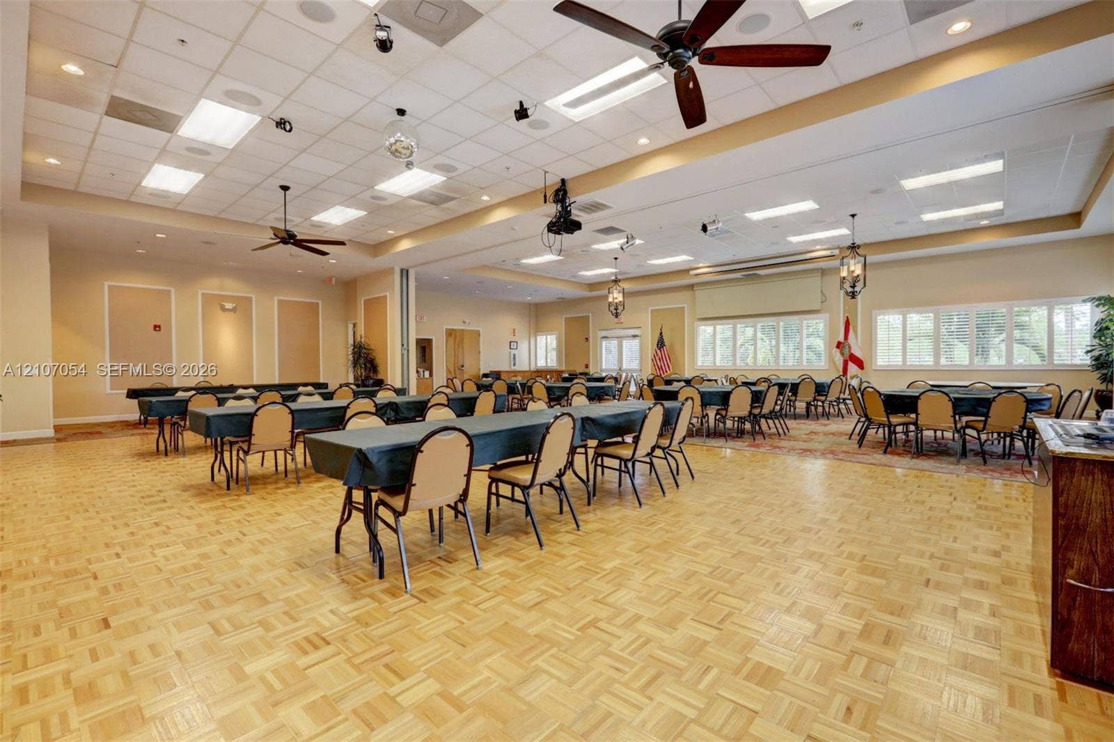 210 NW Zanzibar Place, Port St Lucie, FL 34986 Clubhouse featuring expansive hall featuring parquet wood-finish flooring, a coffered ceiling with recessed lighting, multiple ceiling fans, and large paneled windows