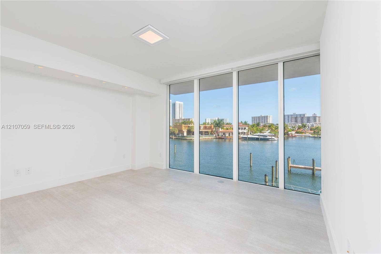 400 Sunny Isles Boulevard, #121, Sunny Isles Beach, FL 33160 Floor-to-ceiling windows, light-toned wood-finish flooring, recessed ceiling lighting, and waterfront surroundings