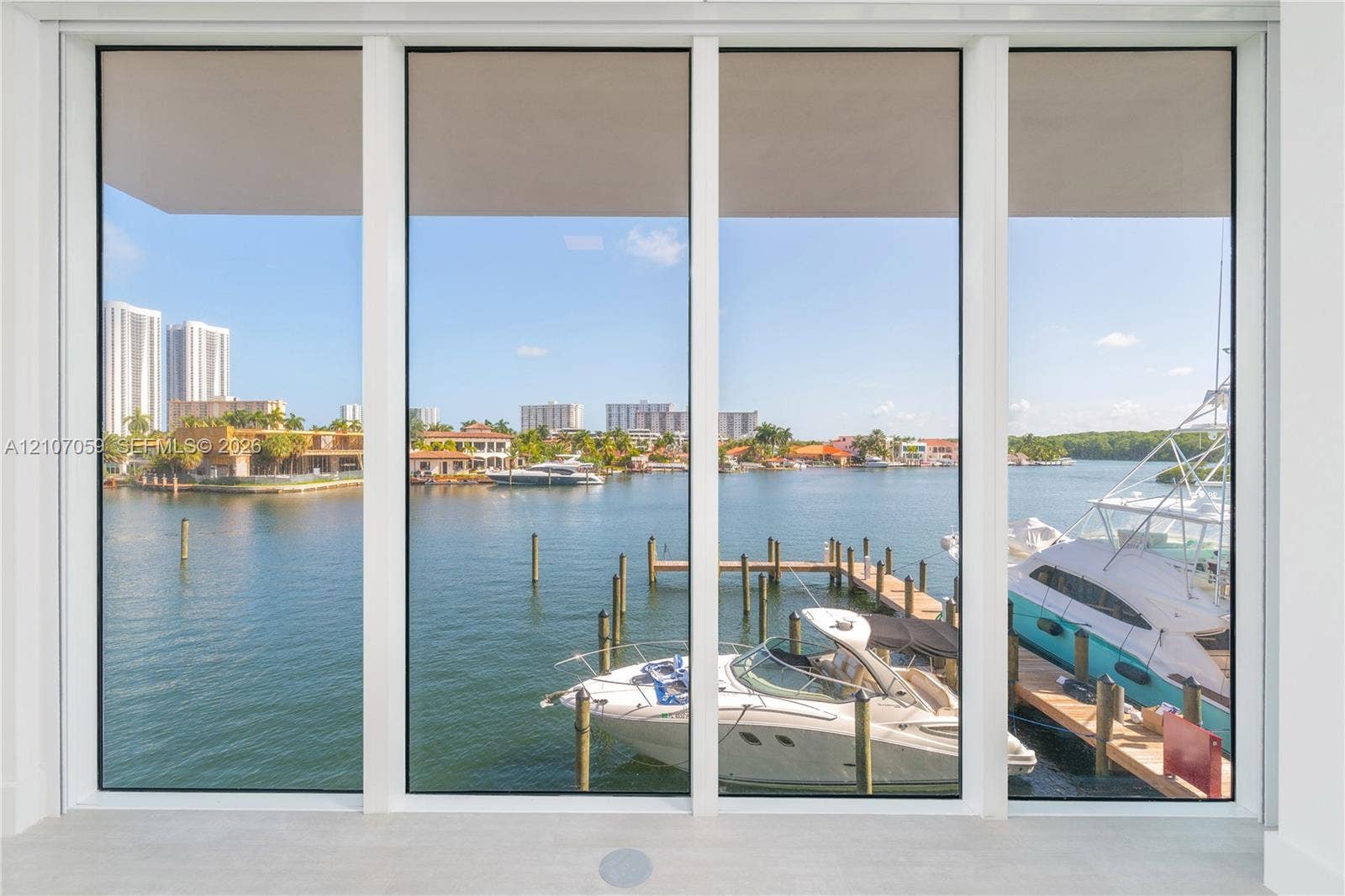 400 Sunny Isles Boulevard, #121, Sunny Isles Beach, FL 33160 Floor-to-ceiling picture windows featuring a multi-panel design and white frames, overlooking a private dock on the waterway