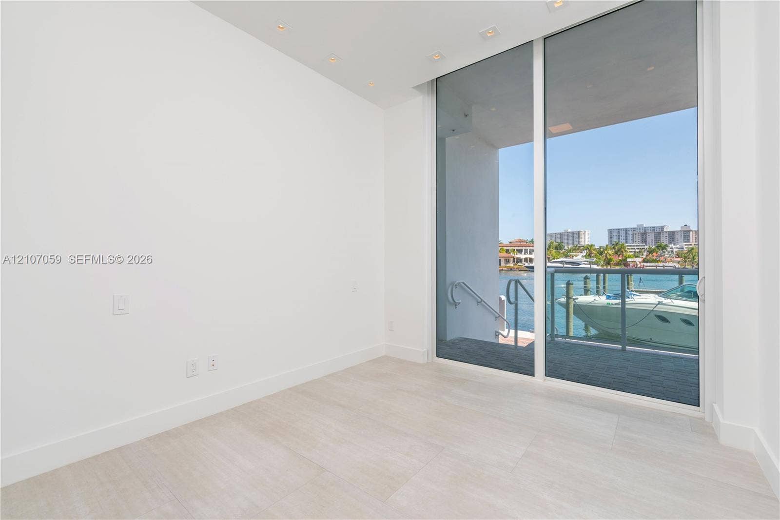 400 Sunny Isles Boulevard, #121, Sunny Isles Beach, FL 33160 Floor-to-ceiling sliding glass doors, light-toned tile flooring, recessed ceiling lighting, and a private balcony with water-front access
