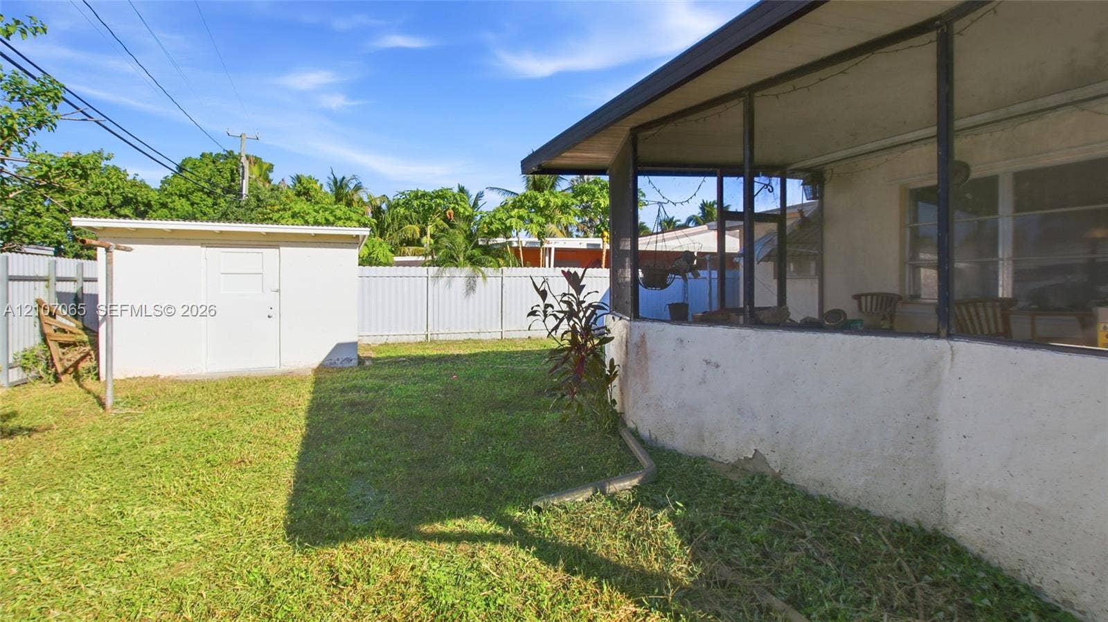 Screened-in rear porch, fenced yard, and detached storage shed