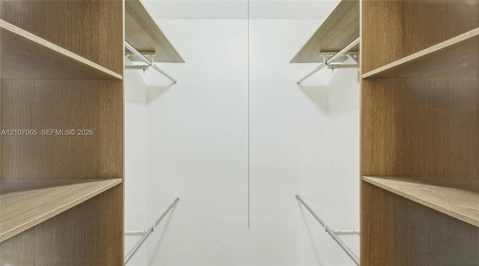 Custom closet storage featuring wood-finish shelving and integrated metal garment rods