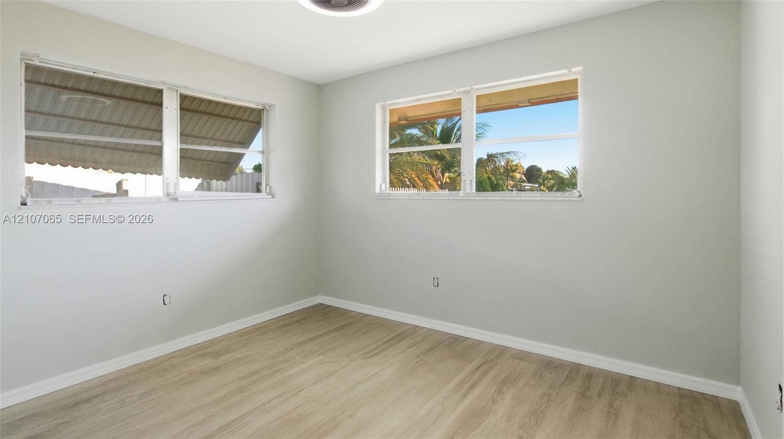 Neutral wall finishes, wood-finish flooring, and multiple dual-pane windows providing natural light