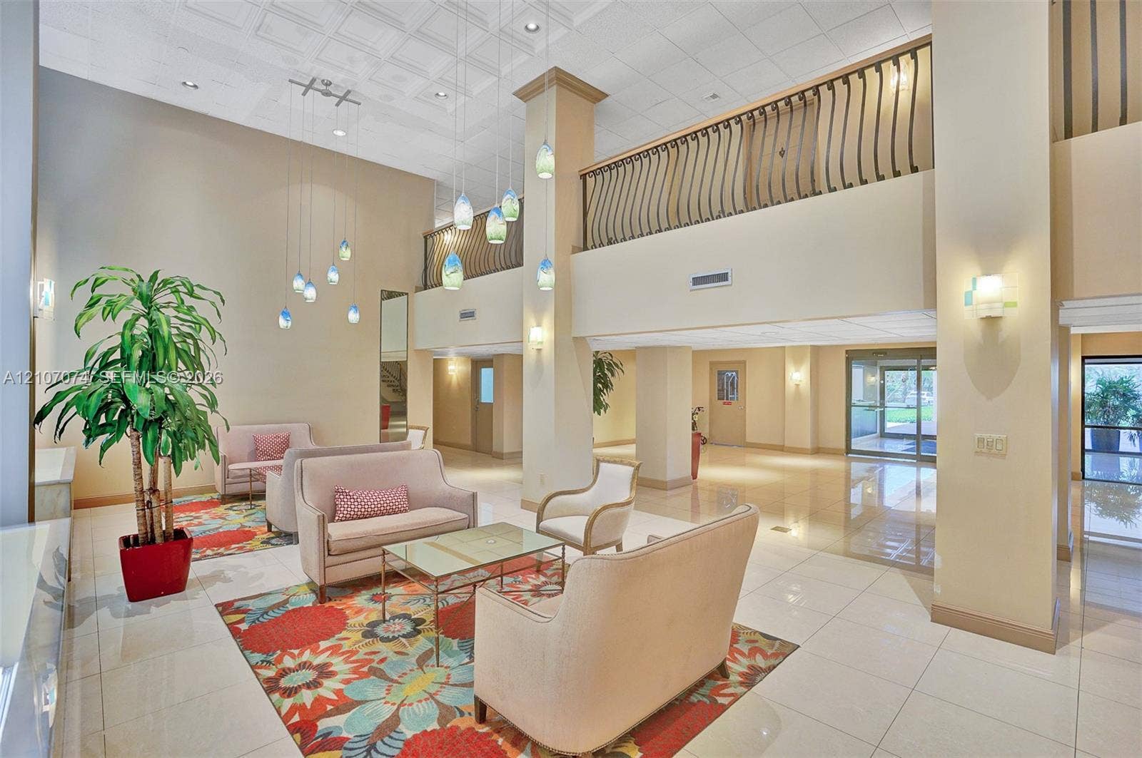 1201 S Ocean Drive, #218N, Hollywood, Hollywood, FL 33019 Two-story atrium featuring polished tile flooring, a tiered pendant lighting fixture, and a decorative wrought iron mezzanine railing