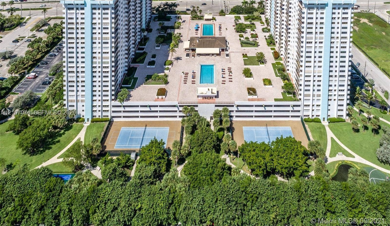 1201 S Ocean Drive, #218N, Hollywood, Hollywood, FL 33019 Aerial perspective featuring two outdoor swimming pools, two hard-court tennis courts, extensive paved sun decks, and mature landscaping