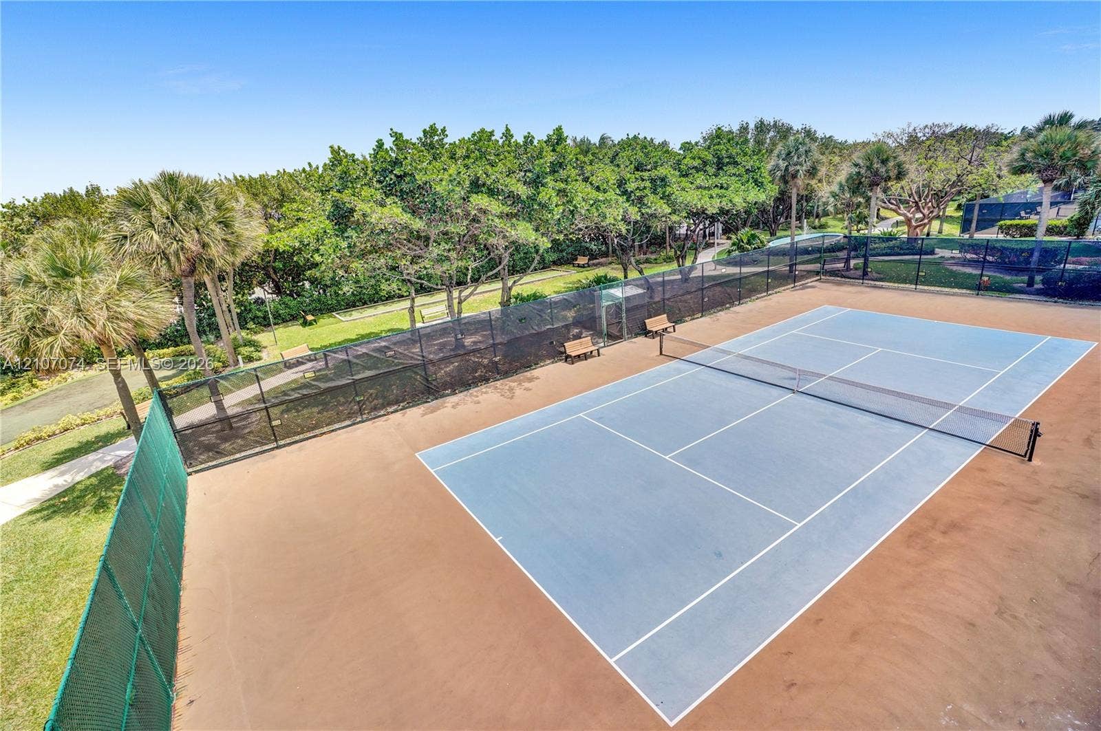 1201 S Ocean Drive, #218N, Hollywood, Hollywood, FL 33019 Tennis court featuring a blue hard-surface finish, perimeter chain-link fencing, and integrated net