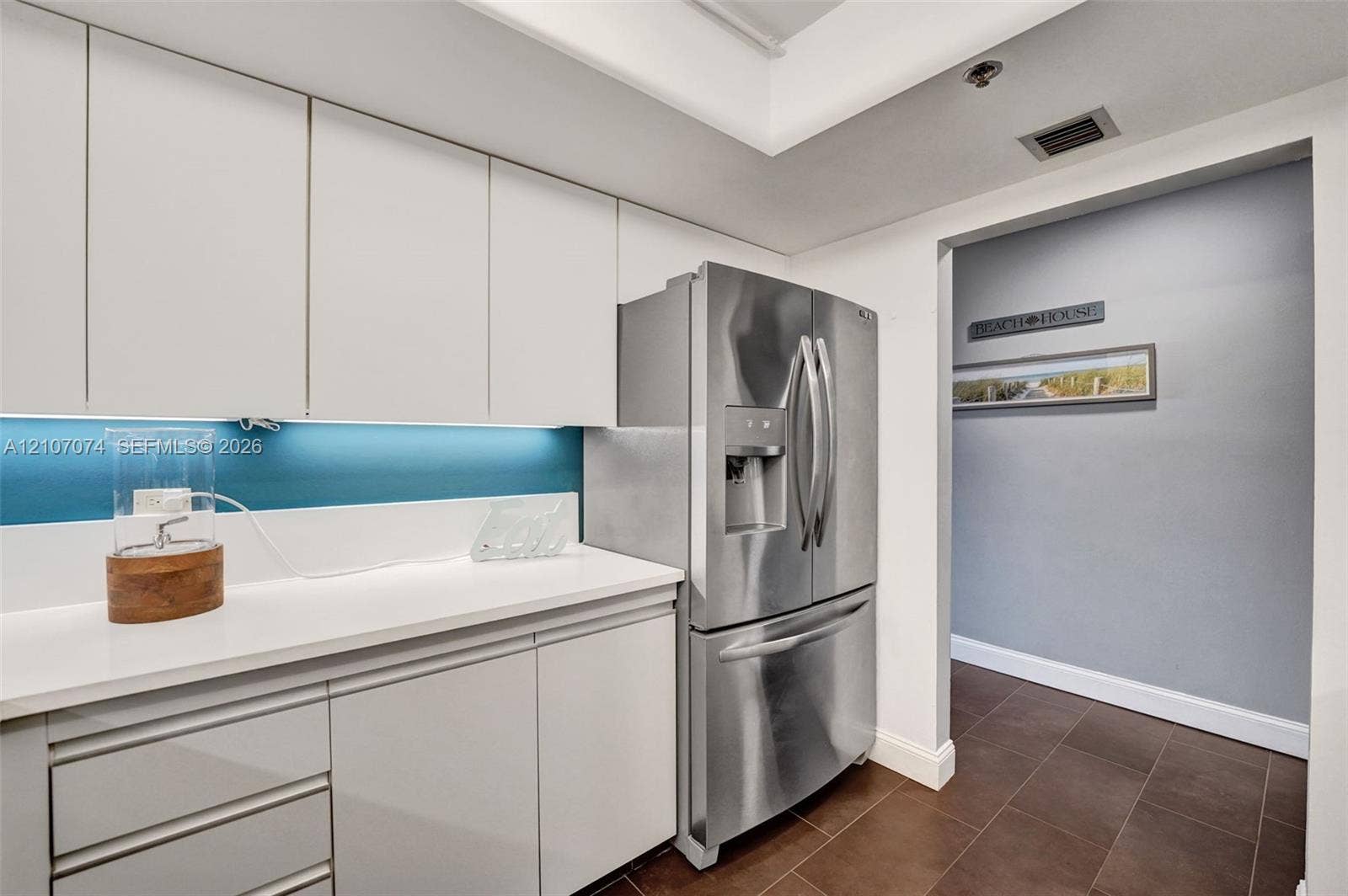 1201 S Ocean Drive, #218N, Hollywood, Hollywood, FL 33019 Flat-panel cabinetry, white solid-surface countertops, blue-tinted integrated backsplash, and stainless steel French-door refrigerator
