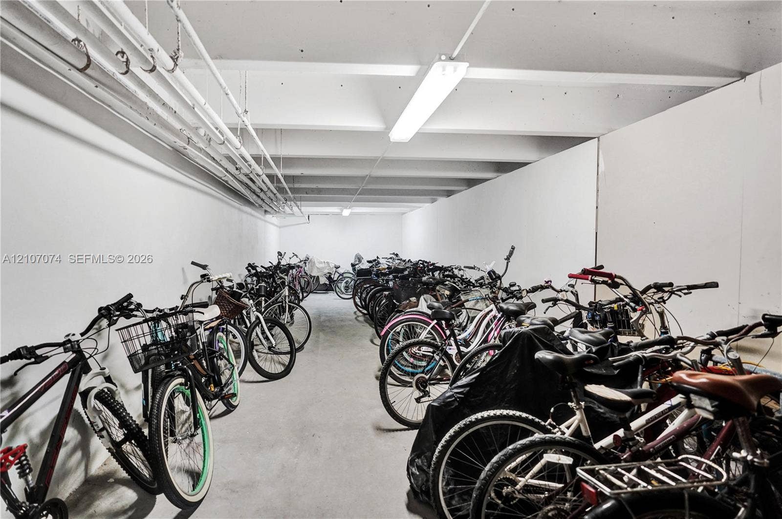 1201 S Ocean Drive, #218N, Hollywood, Hollywood, FL 33019 Enclosed storage area featuring concrete flooring, white walls, exposed utility piping, and overhead fluorescent lighting