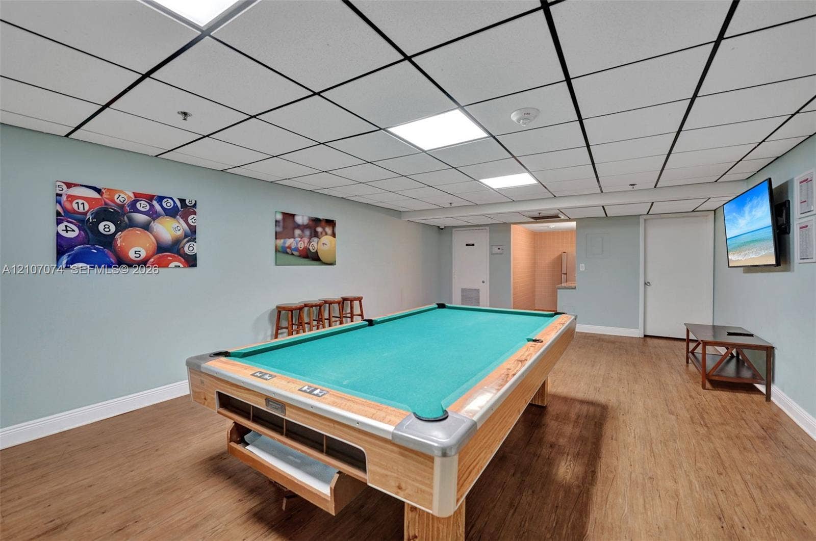 1201 S Ocean Drive, #218N, Hollywood, Hollywood, FL 33019 Finished recreation room featuring wood-finish flooring, a drop ceiling with recessed panel lighting, and solid-core interior doors